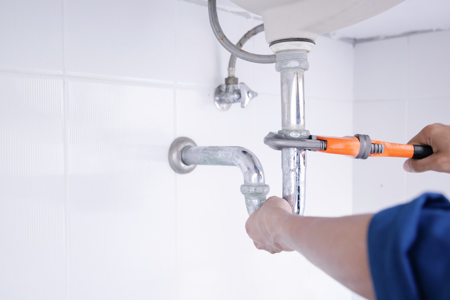 Plumber working in the bathroom, plumbing repair service.